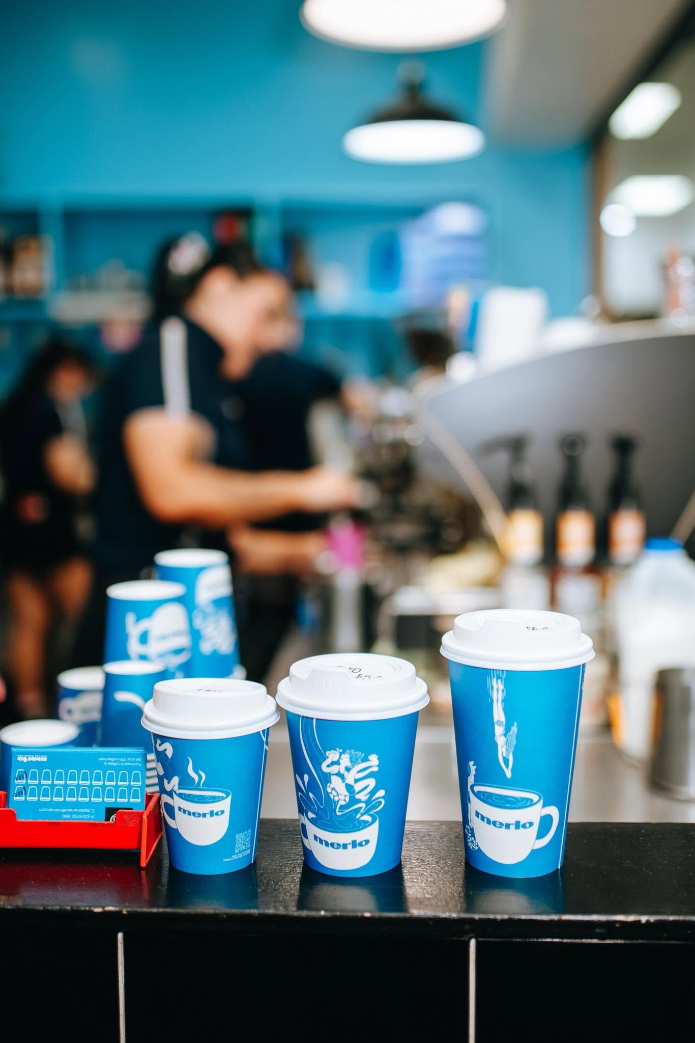 Merlo takeaway cups lined up on the counter at T-Table